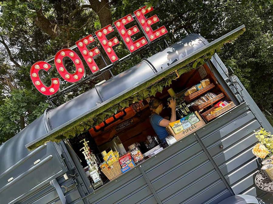 The marquee COFFEE sign glowing above the van in the evening light